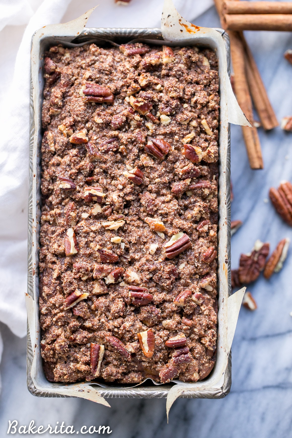 This Paleo Cinnamon Streusel Banana Bread has a layer of pecan crumble in the center and on top, creating a ripple of cinnamon flavor throughout the whole loaf of banana bread. This moist gluten-free + refined sugar free bread is sweetened with bananas and made with coconut flour.