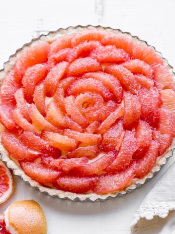 This Grapefruit Tart has a bright, tart grapefruit flavor from the silky grapefruit curd, and it's topped with gorgeous pink grapefruit segments! This gluten-free, Paleo, and refined sugar free tart is a stunning way to show off grapefruit.