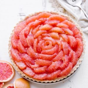 This Grapefruit Tart has a bright, tart grapefruit flavor from the silky grapefruit curd, and it's topped with gorgeous pink grapefruit segments! This gluten-free, Paleo, and refined sugar free tart is a stunning way to show off grapefruit.