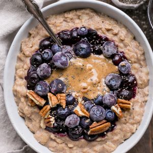 This simple Blueberry Muffin Oatmeal is sweetened with a banana, spiced with cinnamon and topped with an easy blueberry compote! Top with all your favorite toppings for a delicious, healthy + filling breakfast that is far from boring.