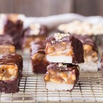 These Homemade Snickers Bars are a healthier version of the classic candy with no baking required! These gluten-free and vegan candy bars have a layer of raw nougat, topped with a peanut date caramel, all dunked in homemade chocolate.