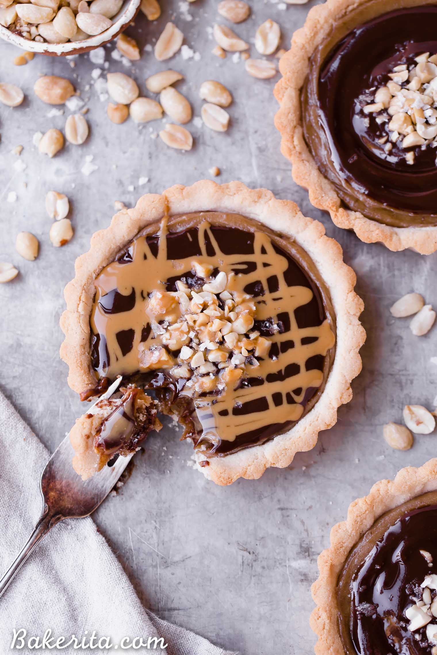These Chocolate Peanut Butter Caramel Tarts have a crunchy shortbread crust that's filled with a creamy peanut butter date caramel and topped with creamy chocolate ganache! This decadent tart recipe is gluten-free, grain-free and vegan.