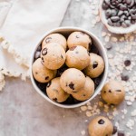Oatmeal Chocolate Chip Cookie Dough Bites: Gluten Free & Vegan. Stacked in a bowl with oats and chocolate chips.