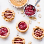 These Peanut Butter & Jelly Tartlets are made with just SEVEN ingredients! They have a crunchy peanut butter cookie crust, filled with an easy strawberry chia jam and topped with even more peanut butter. These gluten-free, grain-free, and vegan tartlets are as cute as they are delicious!