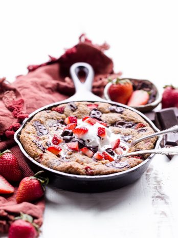 This Strawberry Chocolate Chunk Skillet Cookie is gooey in the middle, with crispy edges and all the flavors you love in a chocolate covered strawberry! This gluten-free, paleo and vegan skillet cookie will satisfy all your cravings - the fresh strawberries are the perfect fruity addition to this rich, chocolatey treat!