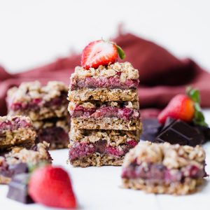 These Strawberry Chocolate Chunk Oatmeal Bars have an oatmeal cookie crust and crumble, filled with fresh strawberries and dark chocolate chunks - it makes for an irresistibly delicious treat! These oatmeal bars are gluten-free, refined sugar-free, and vegan.