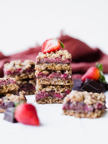 These Strawberry Chocolate Chunk Oatmeal Bars have an oatmeal cookie crust and crumble, filled with fresh strawberries and dark chocolate chunks - it makes for an irresistibly delicious treat! These oatmeal bars are gluten-free, refined sugar-free, and vegan.