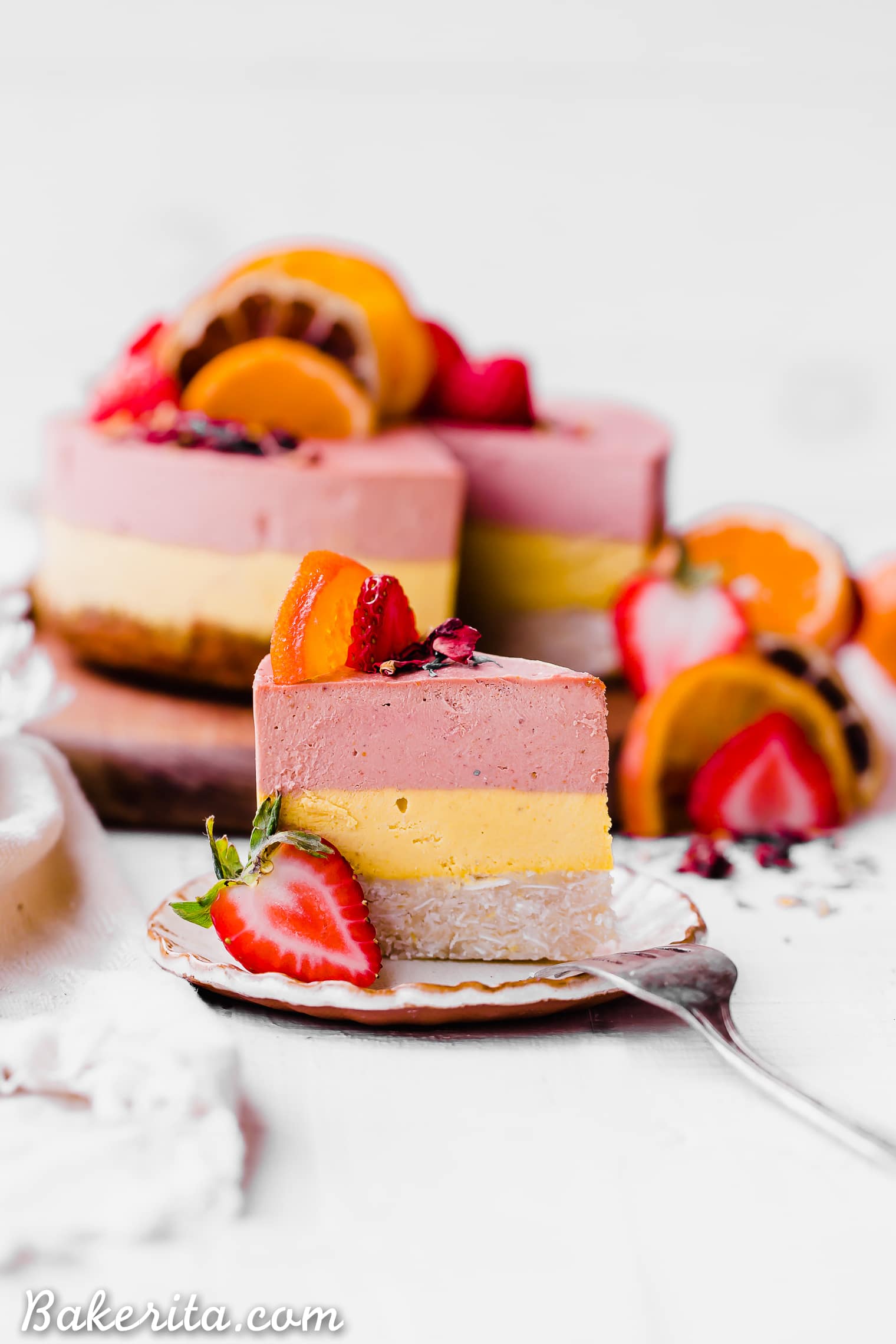 This Strawberry Orange Cheesecake with Coconut Crust is not just beautiful, but it's bright in flavor and absolutely delicious! The lemony coconut macaroon crust is perfect with the strawberry and orange flavors. You're going to adore this gluten-free, paleo and vegan cheesecake. 