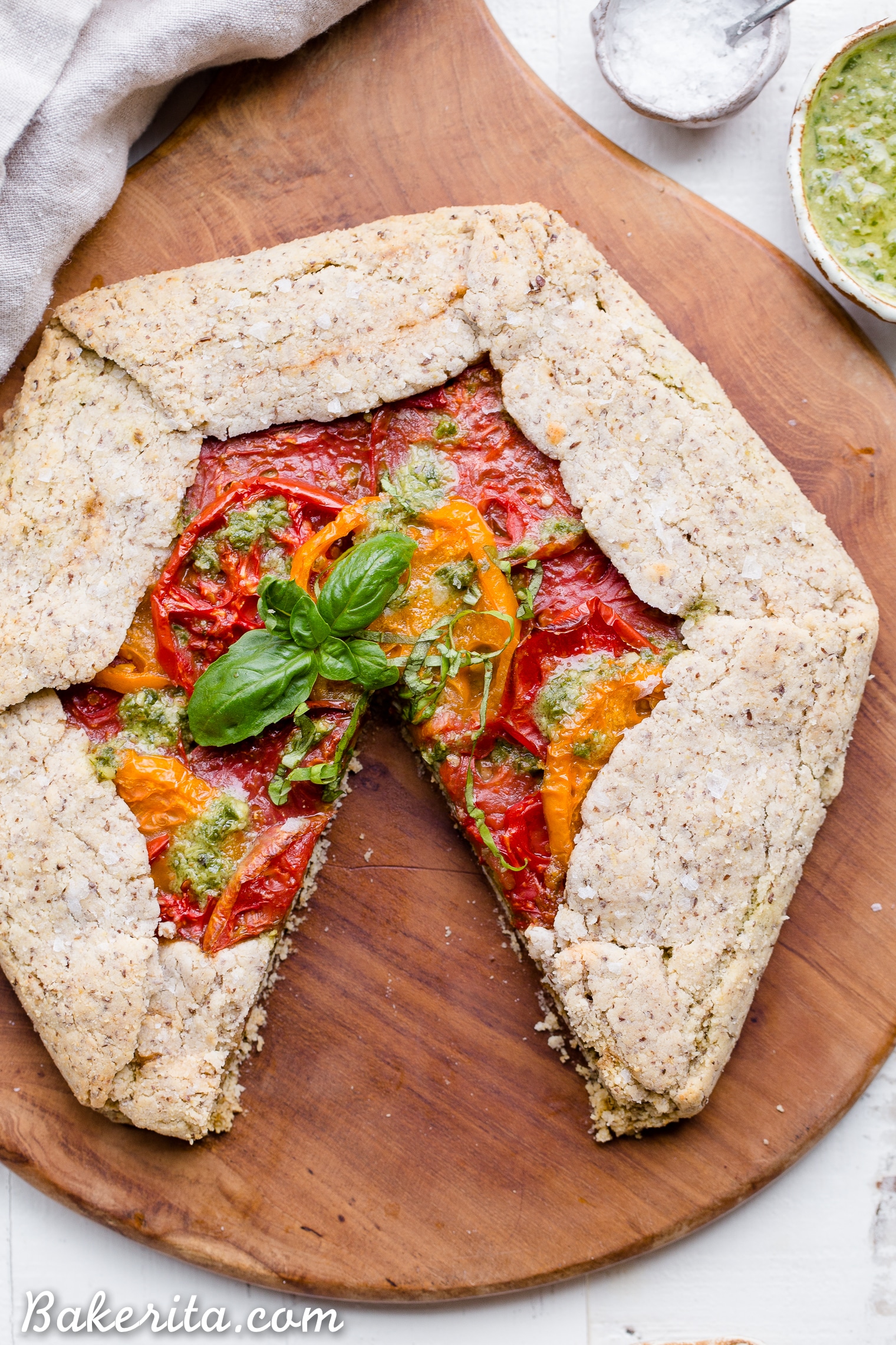 This Pesto + Heirloom Tomato Galette has an incredibly flaky, savory crust filled with homemade pesto and thick slices of heirloom tomatoes. Served warm, it's a truly delicious appetizer or meal that you'd never guess is gluten-free, paleo, and vegan.