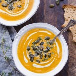 This Butternut Squash Soup is smooth, brightly flavored, and swirled with an easy cashew cream. It's topped off with crunchy spiced pumpkin seeds. This paleo and vegan soup is perfect for chilly days and best served with some crusty gluten-free bread!