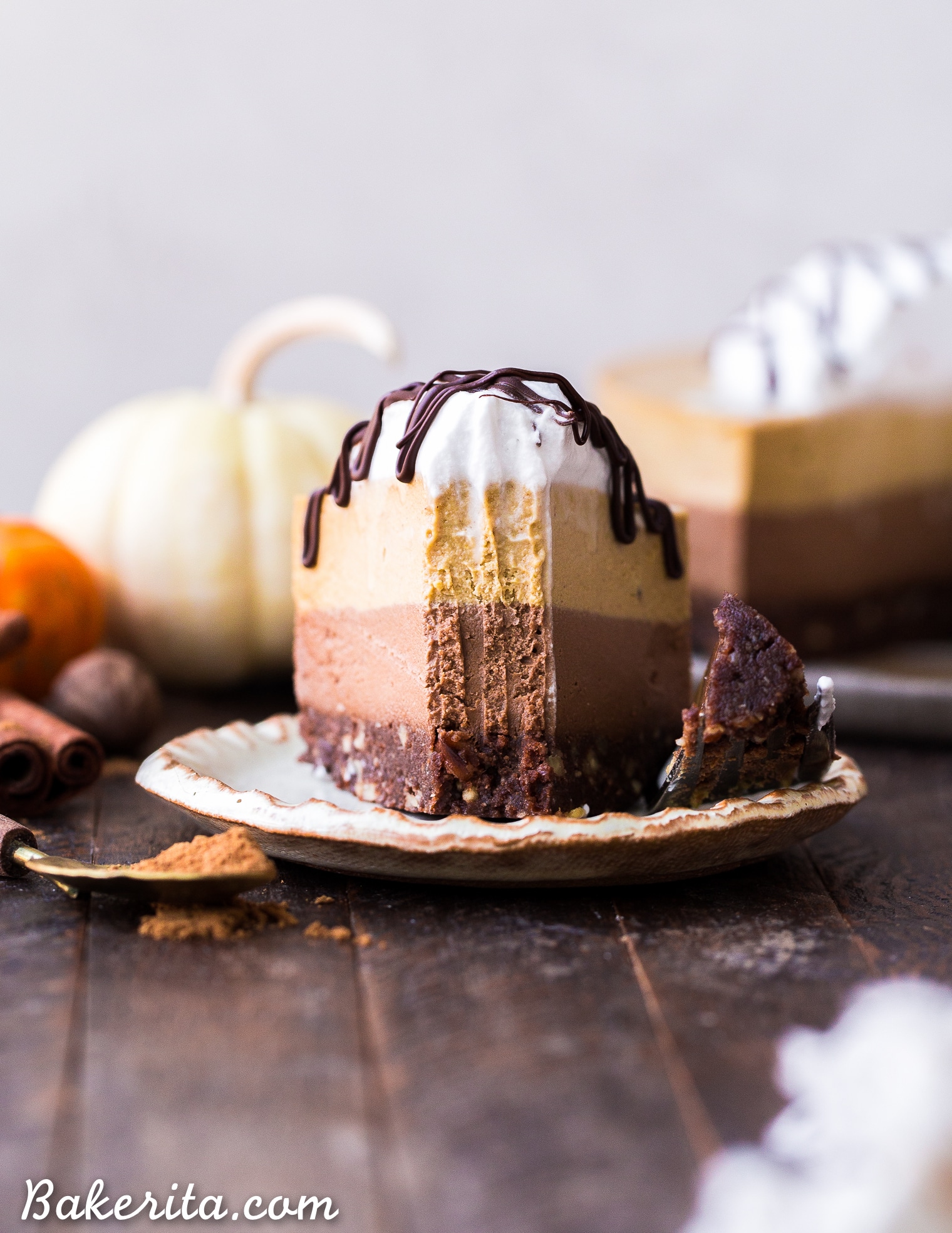 This No-Bake Vegan Chocolate Pumpkin Cheesecake has layers of chocolate and pumpkin spice cashew-based cheesecake, on top of a chocolate date crust. This make-ahead raw dessert is perfect for the holidays.
