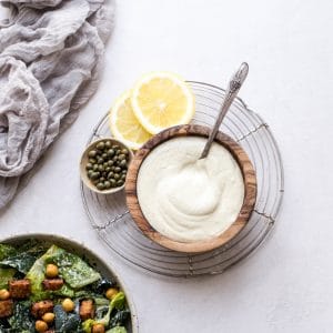 We make this creamy Vegan Caesar Dressing without any dairy, yet it maintains the creaminess you love from a classic Caesar dressing thanks to soaked cashews. The dressing is briny, salty, tart, and so delicious as a salad dressing, a dip, or spread on sandwiches and wraps.