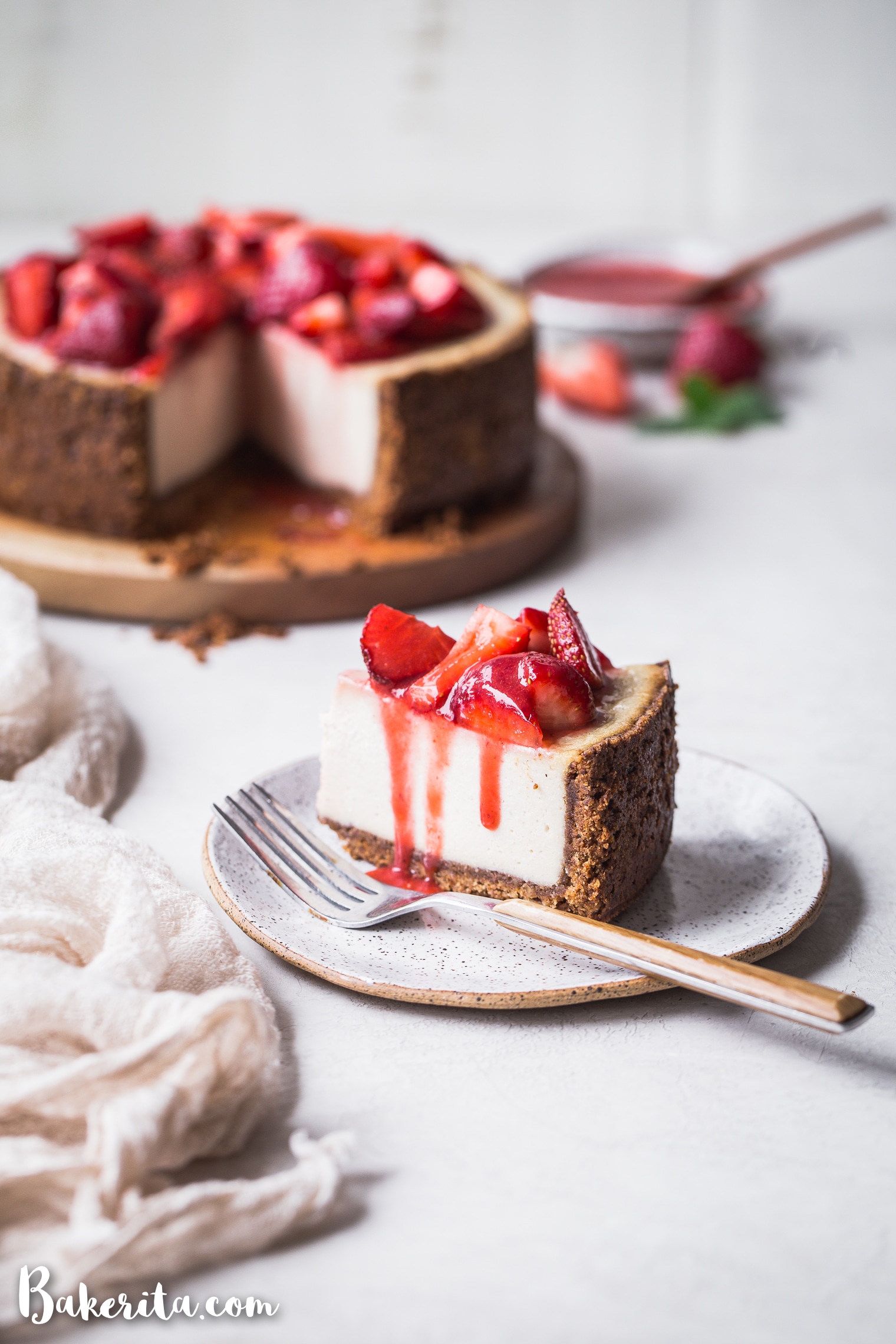 In this Baked Vegan Cheesecake, a gluten-free and paleo graham cracker-style crust encases a sweet and creamy vanilla cheesecake filling. Coconut yogurt and cashews create the perfect texture to mimic a classic cheesecake.