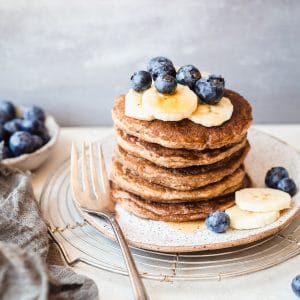 These gluten-free & vegan Banana Blueberry Pancakes are thick, fluffy, and loaded with blueberries! Made in the blender, they come together quickly and reheat well, so you can make them ahead of time for a quick breakfast.