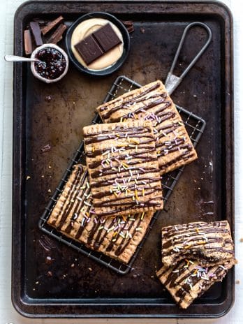 These Chocolate Cashew Butter & Jelly Pop Tarts are made with a flaky vegan and paleo crust and stuffed with cashew butter, raspberry jelly, and chopped Hu Kitchen chocolate. You’re going to go nuts for these paleo & vegan copycat of your favorite childhood treat!