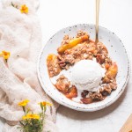 This Gluten-Free & Vegan Peach Crisp recipe is a summer staple! Scented with cinnamon and baked until bubbly, the fresh peaches are perfectly complemented by the pecan crisp topping. Top with a scoop of ice cream for the perfect dessert!