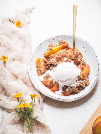 This Gluten-Free & Vegan Peach Crisp recipe is a summer staple! Scented with cinnamon and baked until bubbly, the fresh peaches are perfectly complemented by the pecan crisp topping. Top with a scoop of ice cream for the perfect dessert!
