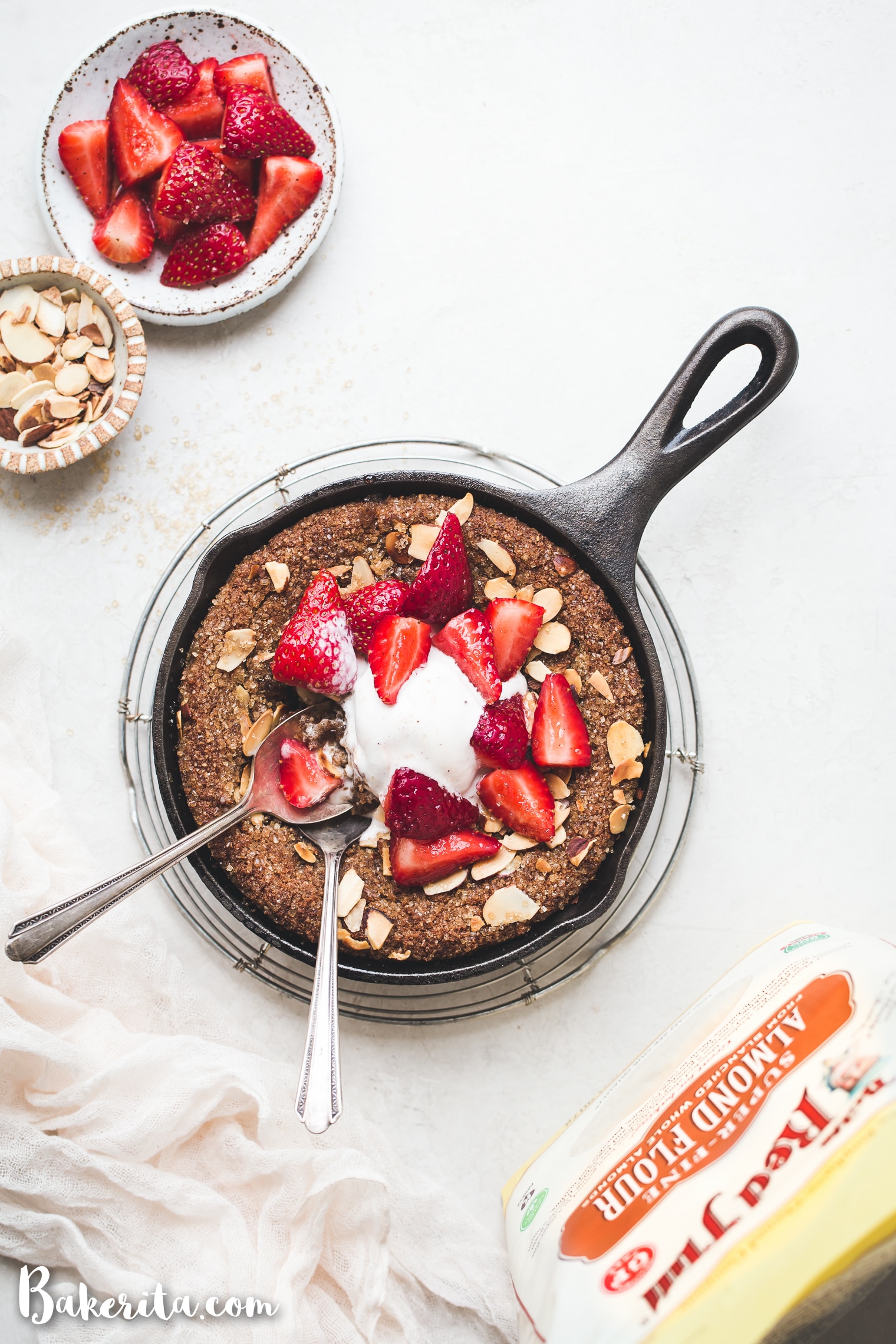 This Gluten-Free & Vegan Sugar Cookie Skillet will make your mouth water! You'll love this easy sugar cookie recipe - it's gluten-free, vegan, paleo, and topped with sliced almonds and raw turbinado sugar.