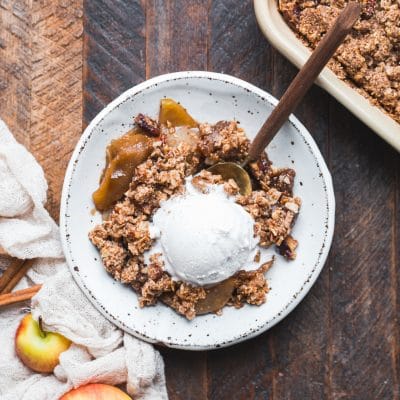 This Gluten-Free Vegan Apple Crisp will have you serving yourself seconds! With a luscious caramel apple filling and oatmeal crumble topping, this vegan holiday dessert is irresistible.