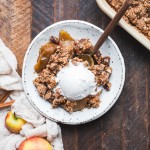 This Gluten-Free Vegan Apple Crisp will have you serving yourself seconds! With a luscious caramel apple filling and oatmeal crumble topping, this vegan holiday dessert is irresistible.