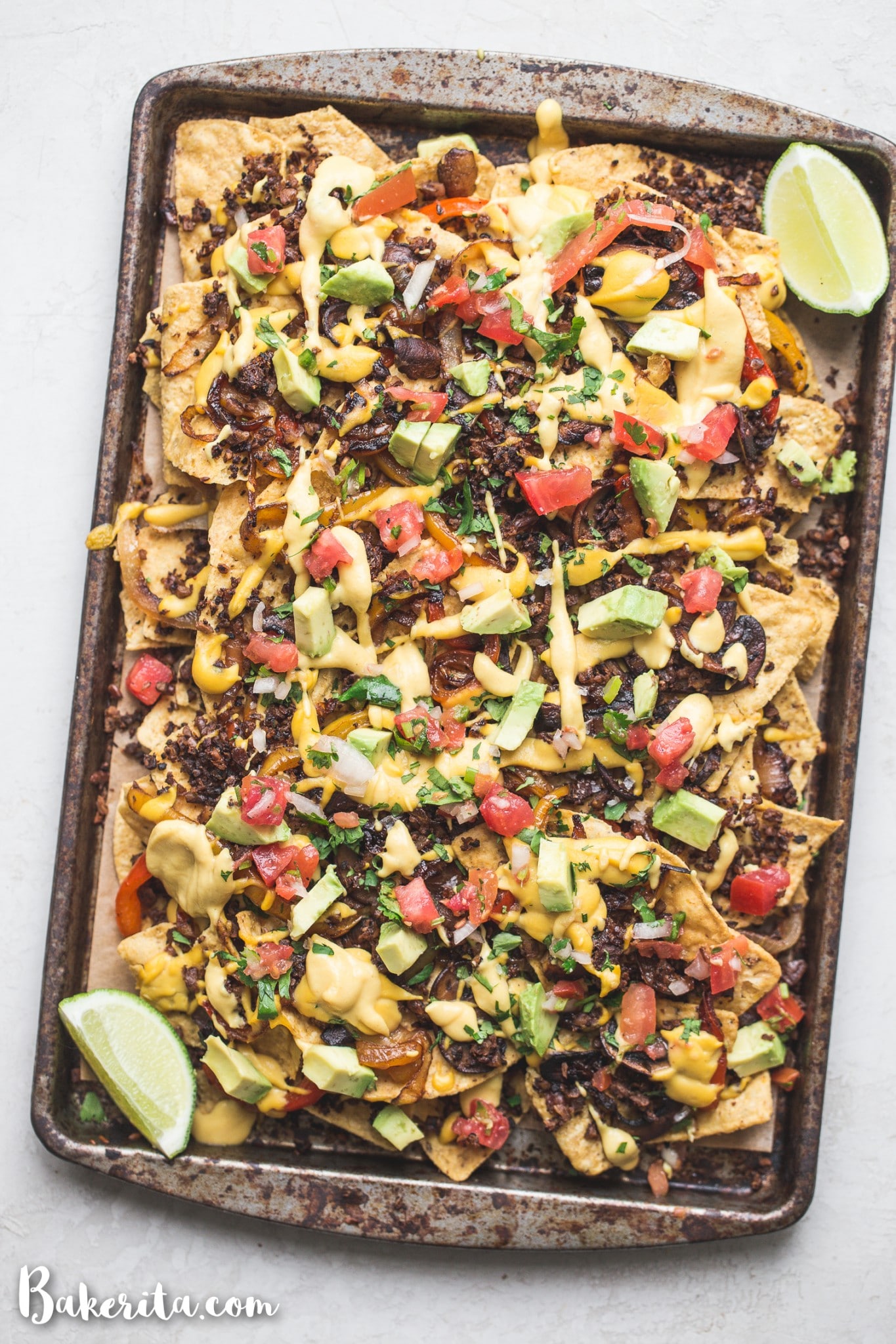 These are the BEST Vegan Nachos I've ever had! They're loaded with sauteed vegetables, vegan taco meat, pico de gallo, avocado, cilantro, and topped with a ton of vegan cheese sauce. They're the perfect cheesy snack for game day.
