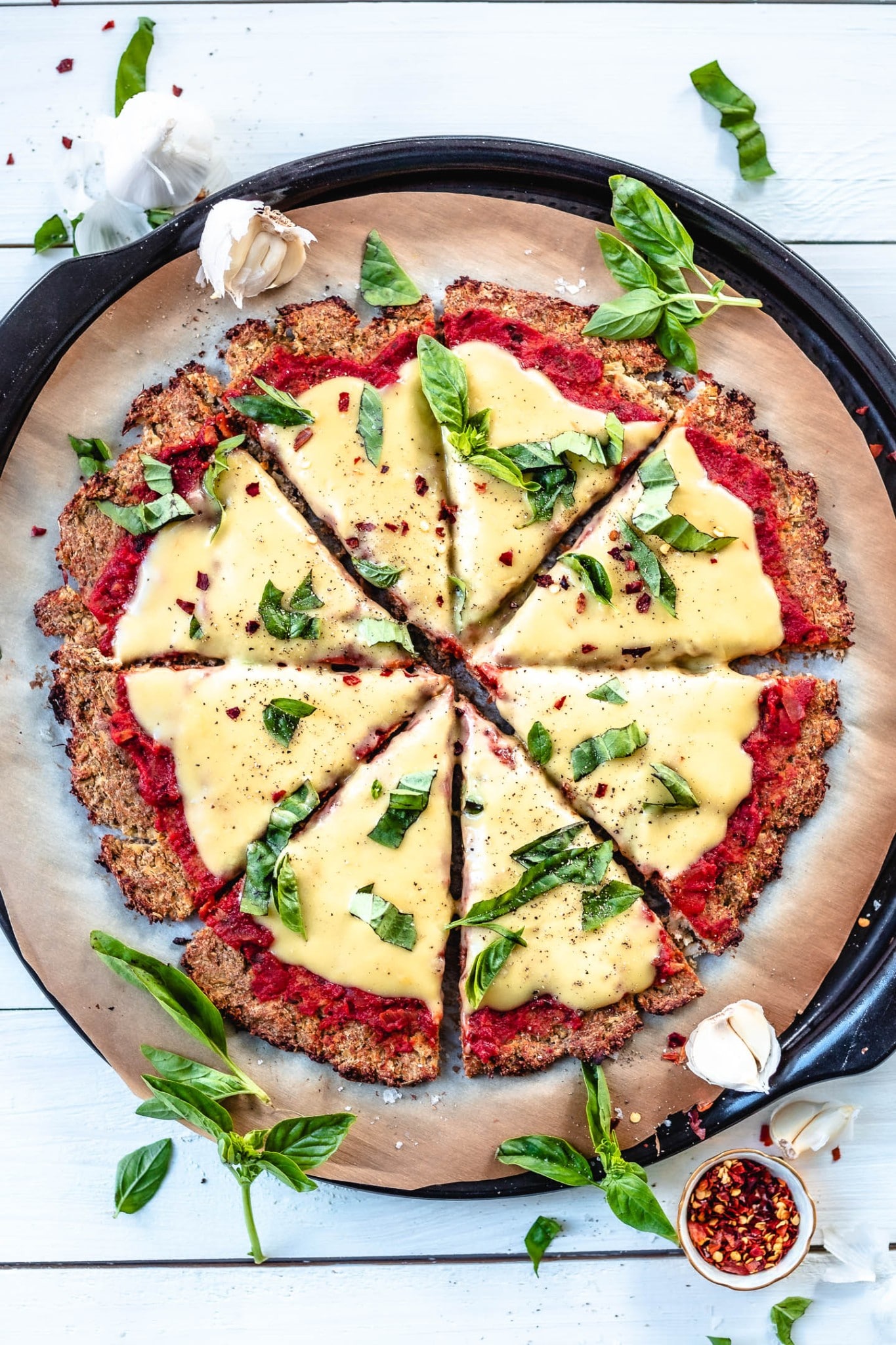 This vegan cauliflower pizza crust is made with just 7 ingredients. It’s crispy and golden, gluten-free and oil-free. Smothered with a simple pizza sauce and topped with homemade vegan mozzarella cheese. All-in-all it’s a warm, savoury, and comforting recipe. Perfect for Friday pizza night.