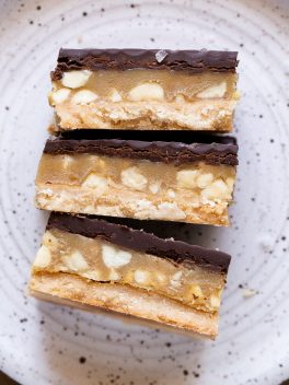 Calling all peanut butter lovers! These Gluten-Free Vegan Peanut Butter Twix Bars will knock your socks off. They have a layer of coconut flour shortbread, a quick no-cook peanut butter caramel, and a layer of dark chocolate.