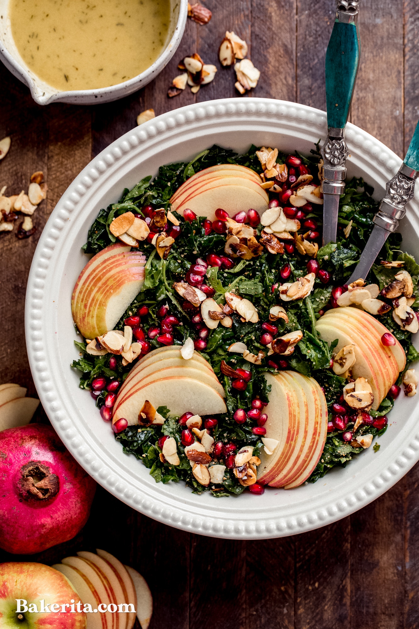 This Autumn Kale Harvest Salad brings together the best of fall's produce into a beautiful salad. With thinly sliced kale, pomegranate seeds, Honeycrisp apple slices, candied almond slices, and tossed in a lusciously sweet and tangy Apple Cider Vinaigrette. It's healthy, simple, beautiful, and the perfect accompaniment to your holiday meal or autumn dinner table.